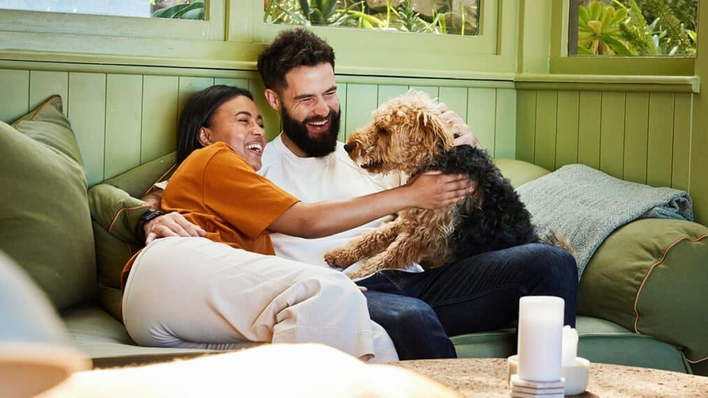 couple-hugging-with-dog-on-couch