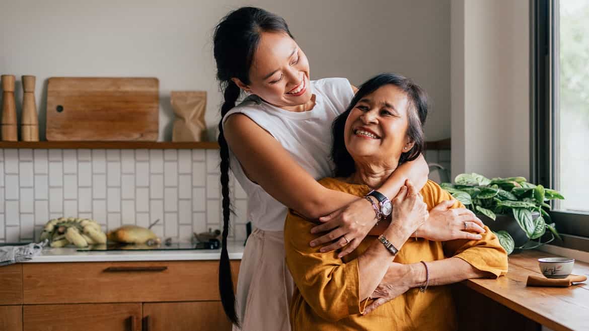 _mother-and-daughter-hugging-in-kitchen