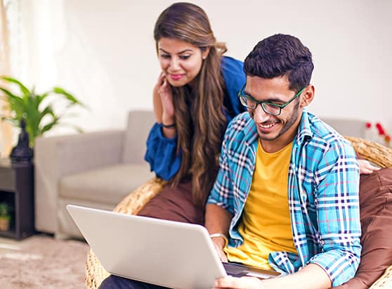 husband and wife looking at accounts on laptop at home