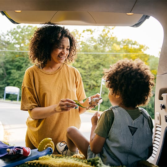 mom-giving-the-son-a-choice-of-toys-in-car_