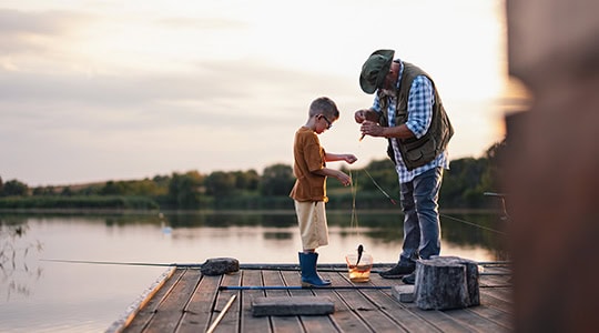 Man teaching grandson how to unhook fish onpoint raymond james investments oregon washington
