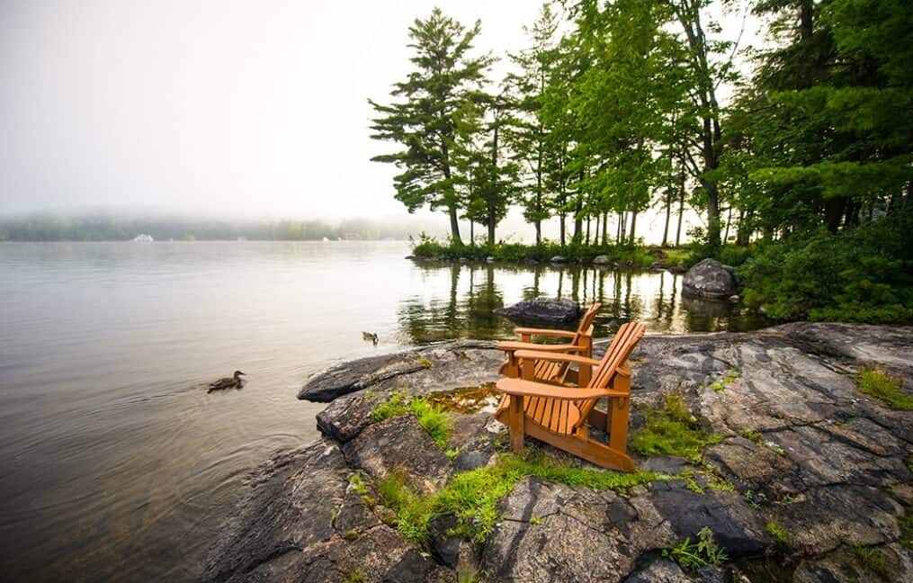 Adirondack chairs on a serene lakeshore