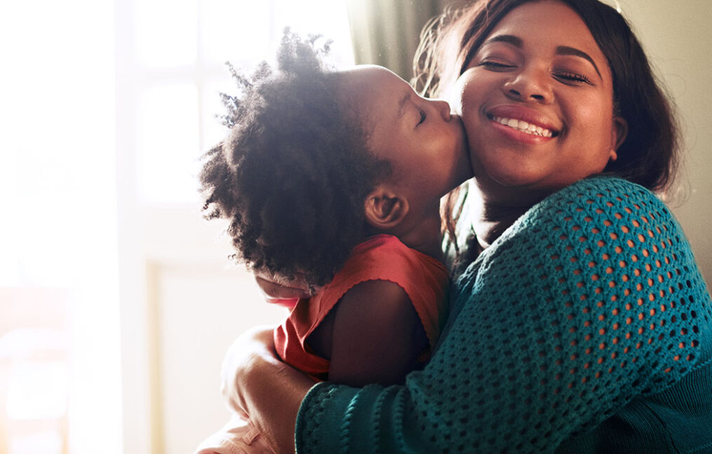 young girl kissing mother on the cheek