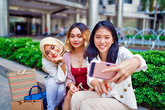 young women taking selfie after shopping