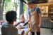 employee helping customer pay for their meal at the table in a restaurant