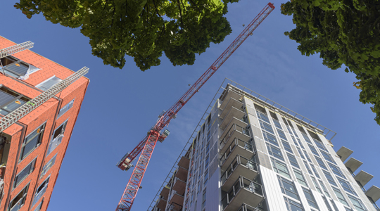 skyward view of two building construction projects and crane
