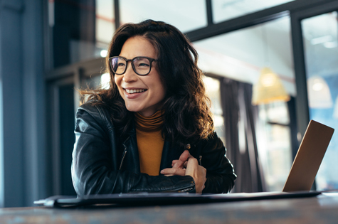 young woman smiling and looking away from her computer