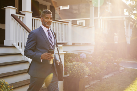 Charitable Foundation and Endowment Planning_professional man walking down in front of his house holding a cup of coffee