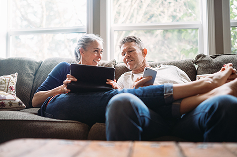 Mature Couple Relaxing with Tablet and Smartphone
