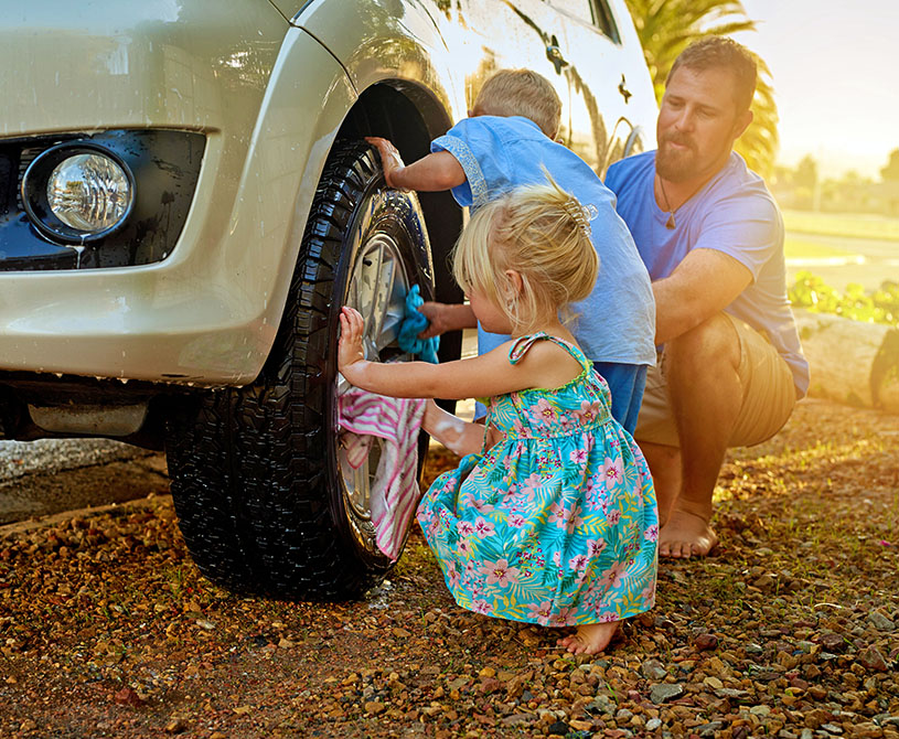 father and kids washing car tires