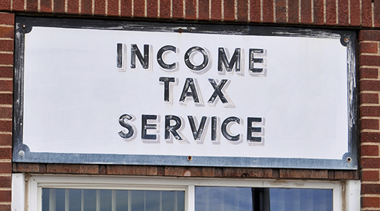 An old and worn sign for Income Tax Service