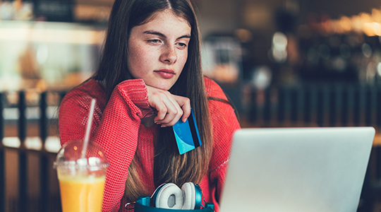 Teenage girl making online payments with credit card