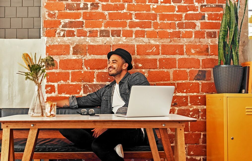 Personal Loans Landing Page-young man sitting at table with-using laptop to apply for personal loan online
