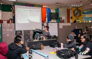 Teacher points out topic on overhead projection screen while students look on in Skyview High School classroom