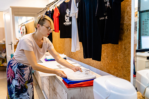 Business owner folding T-shirt in her digital printing workshop