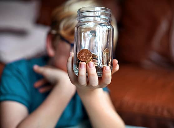 boy-holding-coins-in-jar