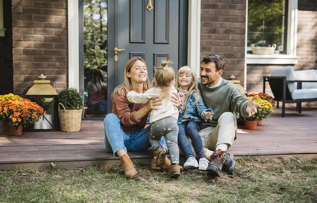Family playing with kids in the yard of new home