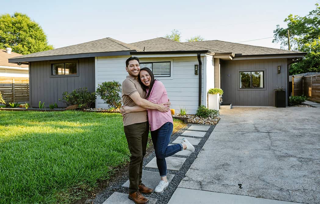 couple hugging excited outside of new home simplifying the homebuying process onpoint