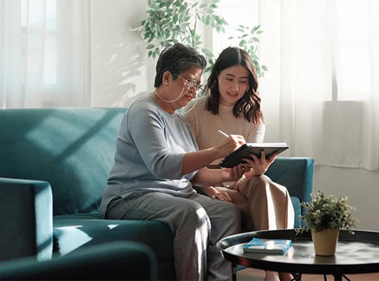 daughter helping older mother on couch green onpoint trusted contact