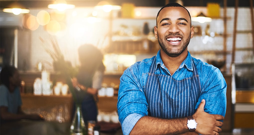 business owner smiling and crossing his hands