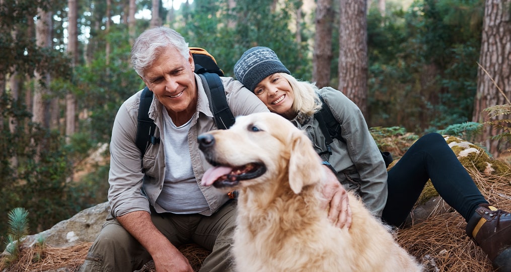 older couple hiking with dog