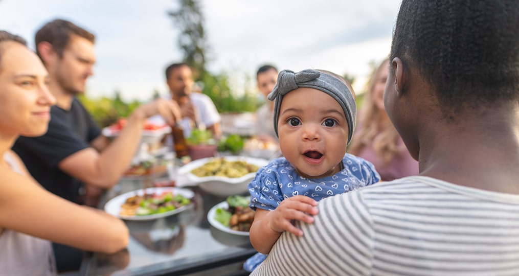 friends having lunch and baby looking over moms shoulder