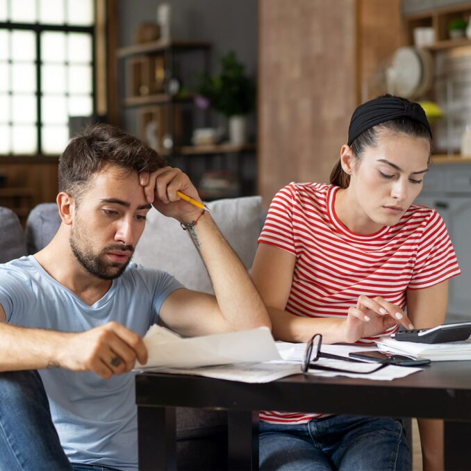 9 ways to pay off holiday credit card debt-frustrated couple reviewing bills