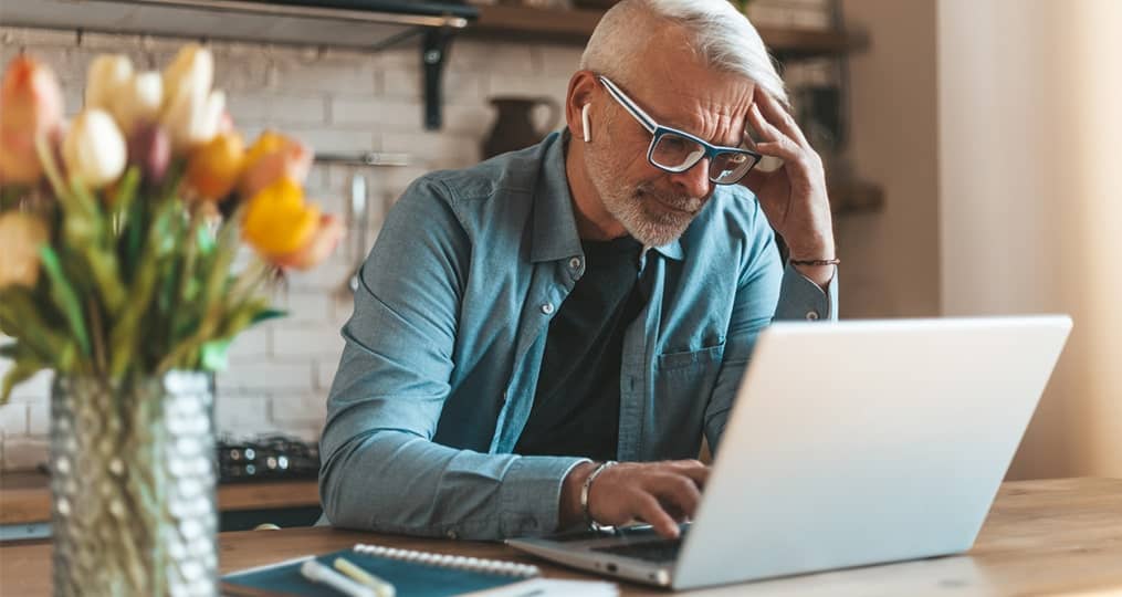 Man using laptop at table.