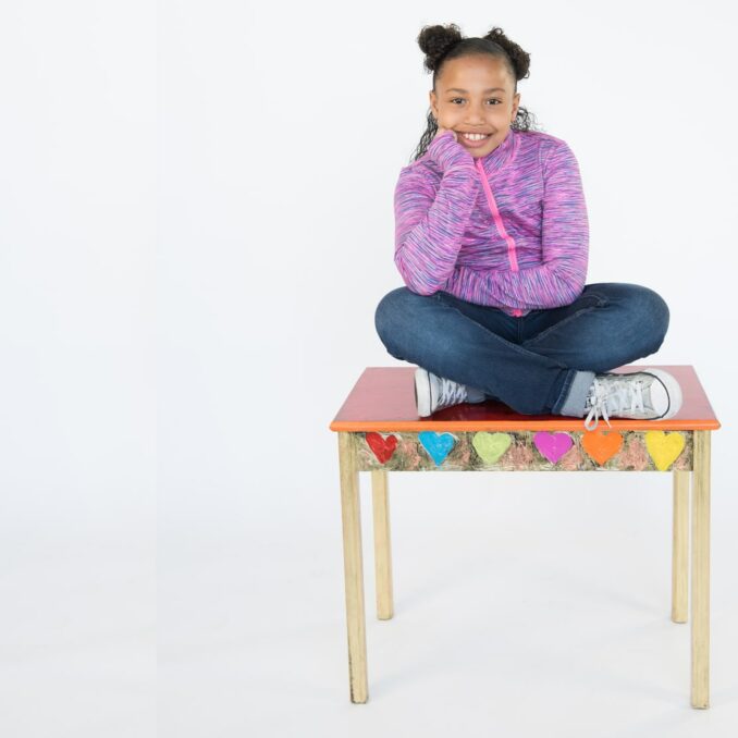 JoyRx Children's Cancer Association-Refer a friend campaign young girl sitting on school desk