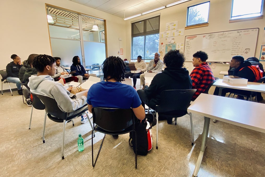 POIC + RAHS-classroom photo with young men listening to teacher