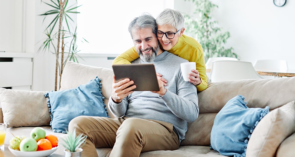 elderly couple looking at a tablet together