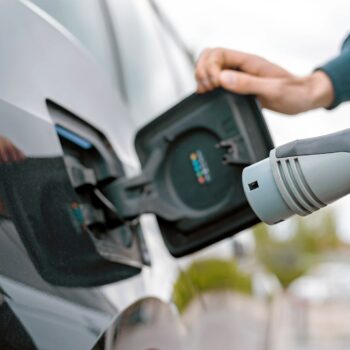 electric vehicles pull out all the stops to attract drivers-man charging electric vehicle