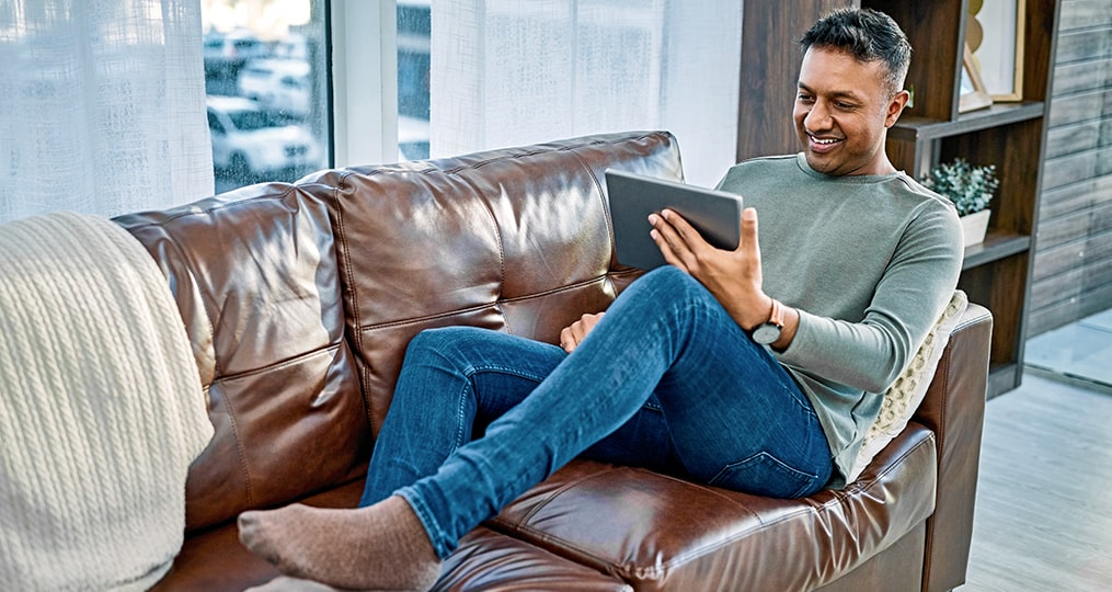 full hands full hearts becoming a caregiver-man sitting on his couch looking at his tablet