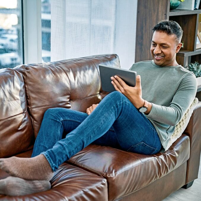 full hands full hearts becoming a caregiver-man sitting on his couch looking at his tablet