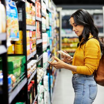 grocery shopping tips-Woman comparing prices at the grocery store