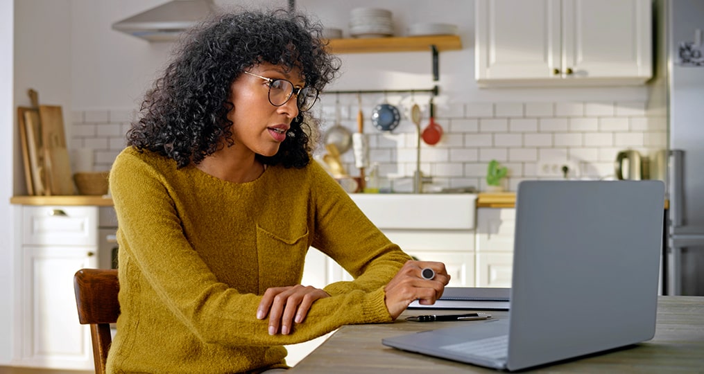 home buyer in a sellers market-focus on your preparation-woman doing research from her laptop in her kitchen