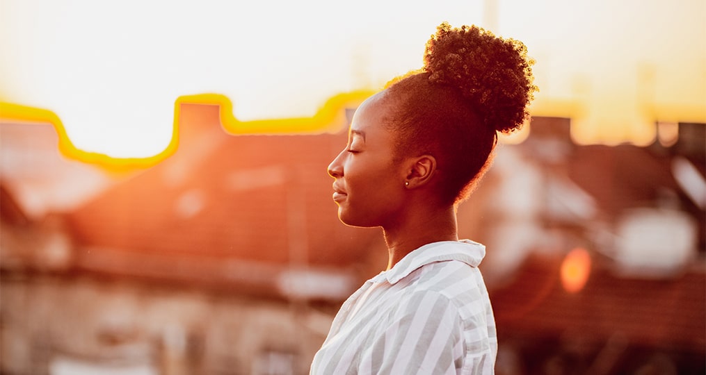 Black women closing her eyes in the sunset