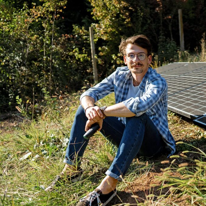 quick facts about the bright future of solar energy-man sitting next to solar panels