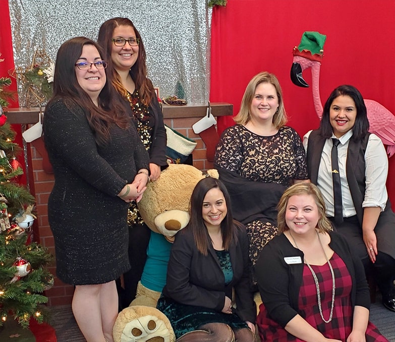 spotlight interview with Maritza Rich-maritza with her OnPoint team near the xmas tree