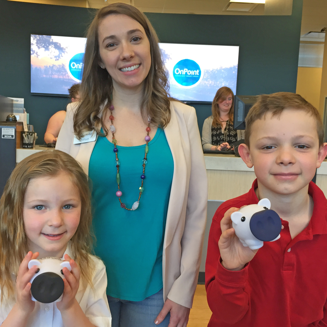 Mother with her two children at an OnPoint branch - each child has an OnPoint Piggy Bank