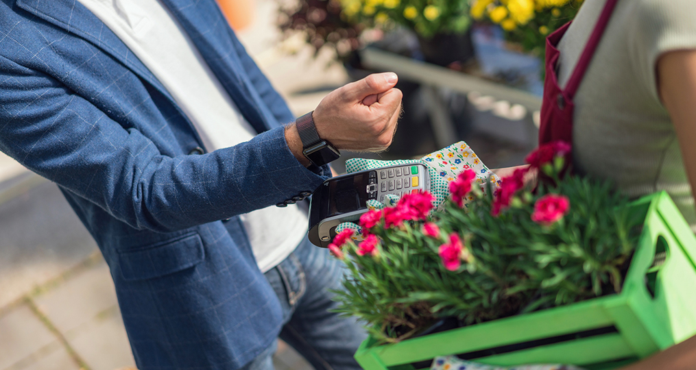 The Pros and Cons of Popular Payment Methods_man using contactless payment at local flower shop