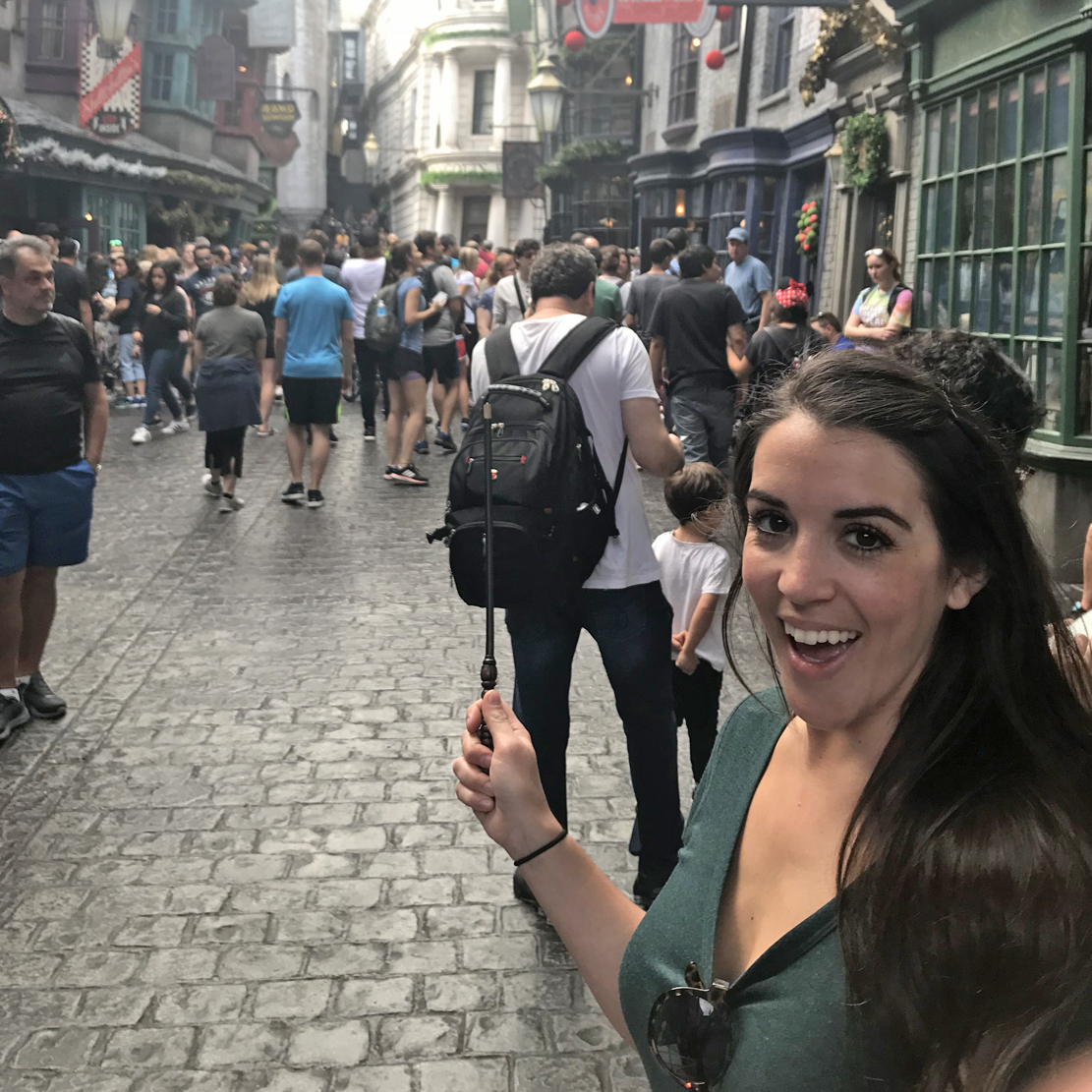 Vanessa waving a wand in diagon alley