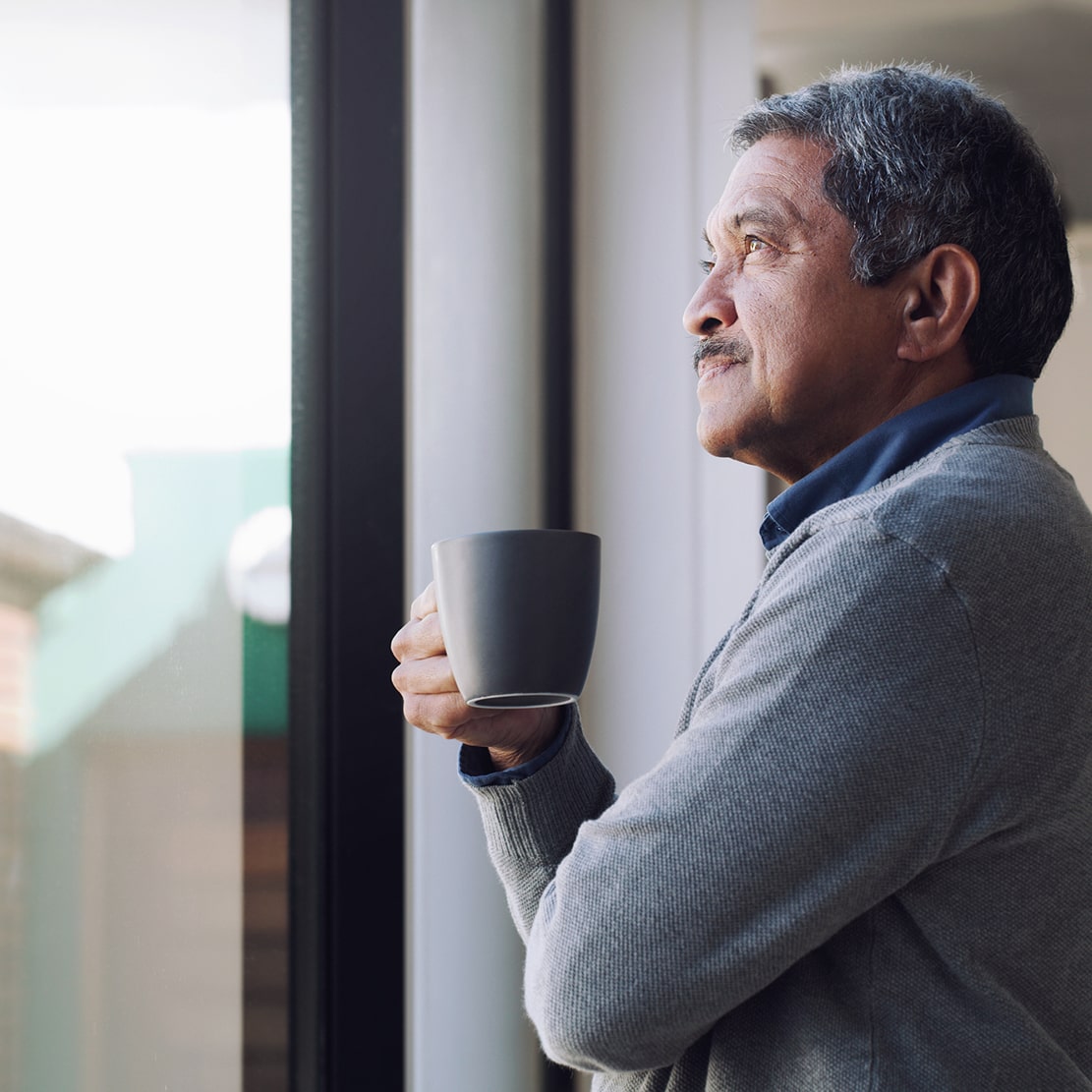 What to Do If You're Not on Track for Retirement_senior drinking coffee while looking out a window