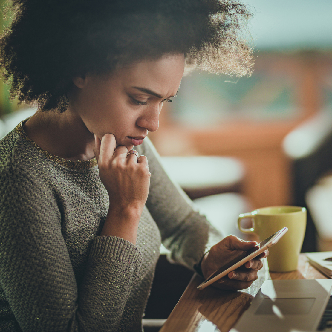 concerned woman looking at her phone