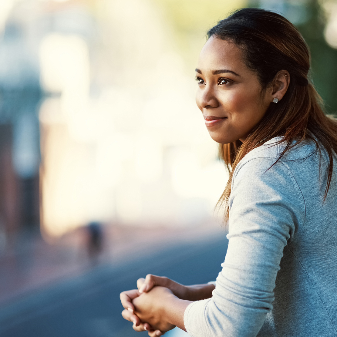 confident woman looking off of her balcony