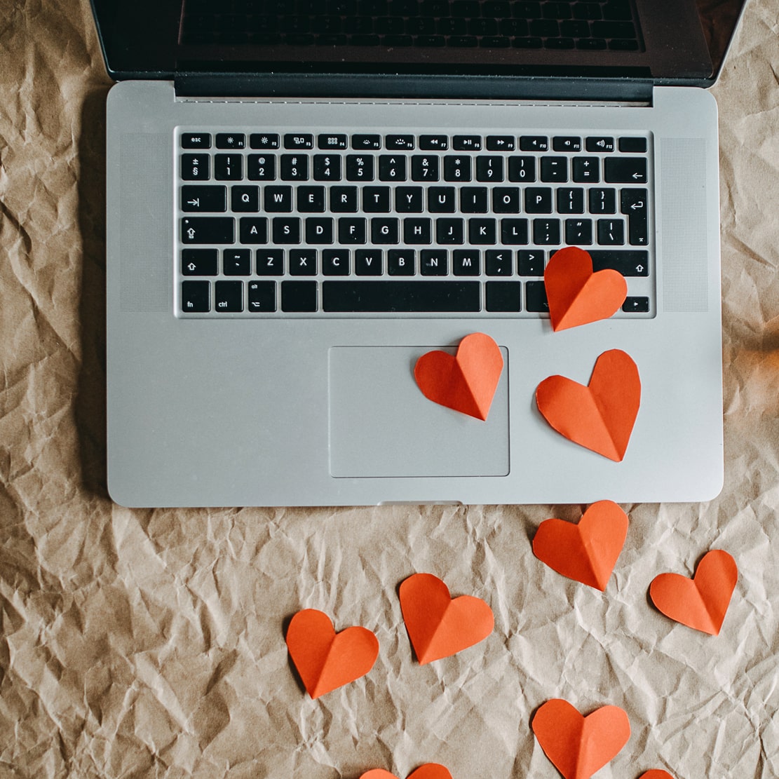 Paper hearts leading to a laptop_don't fall prey to a sweetheart scam