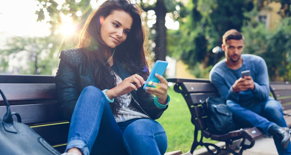 how to avoid getting trapped in a sweetheart scam_man looks over womans shoulder in the park