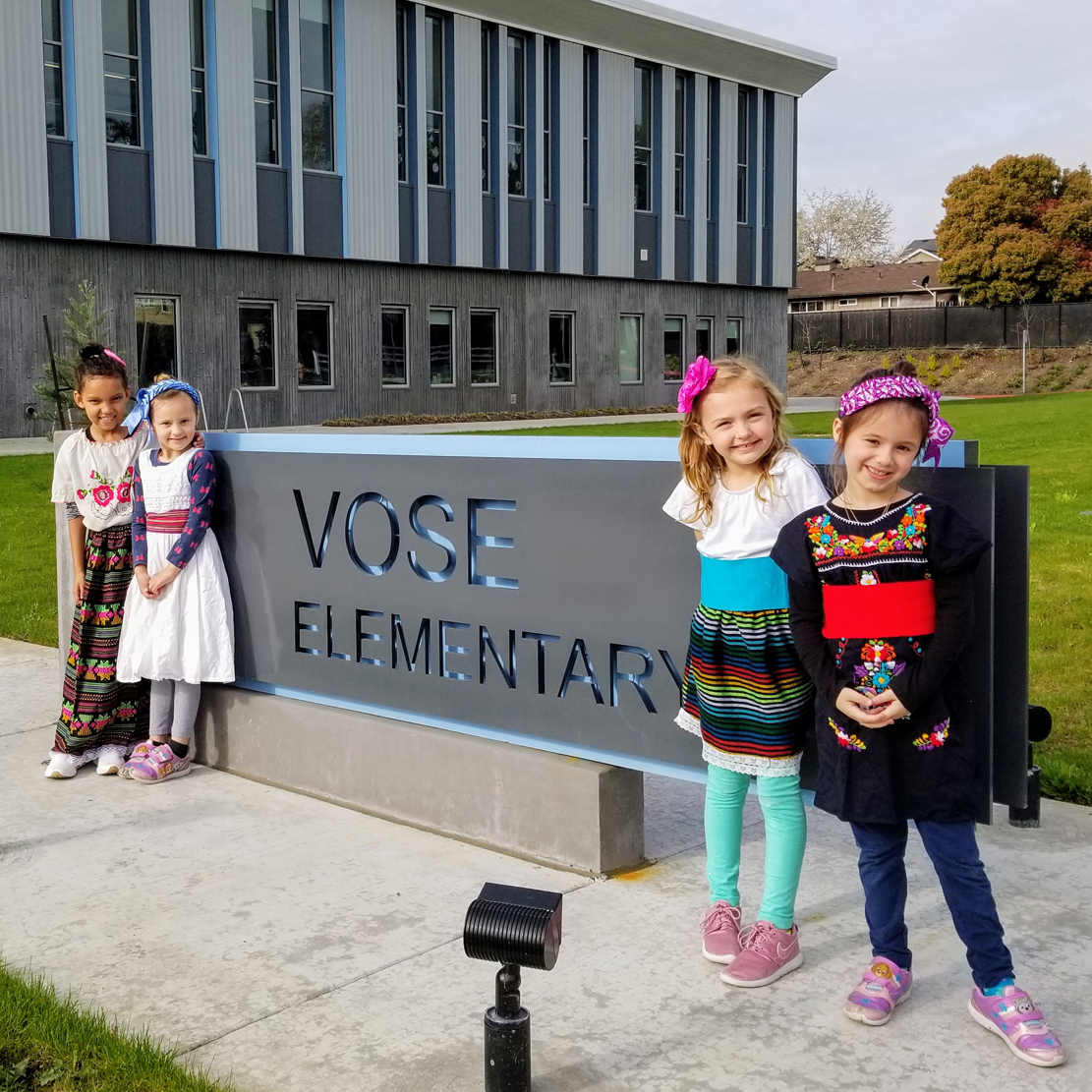 students outside of vose elementary school standing near the school sign