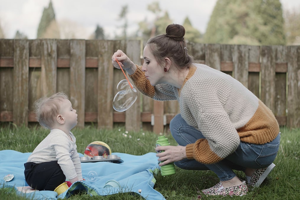 Impact NW—ending Portland homelessness-mother and child blowing bubbles in backyard