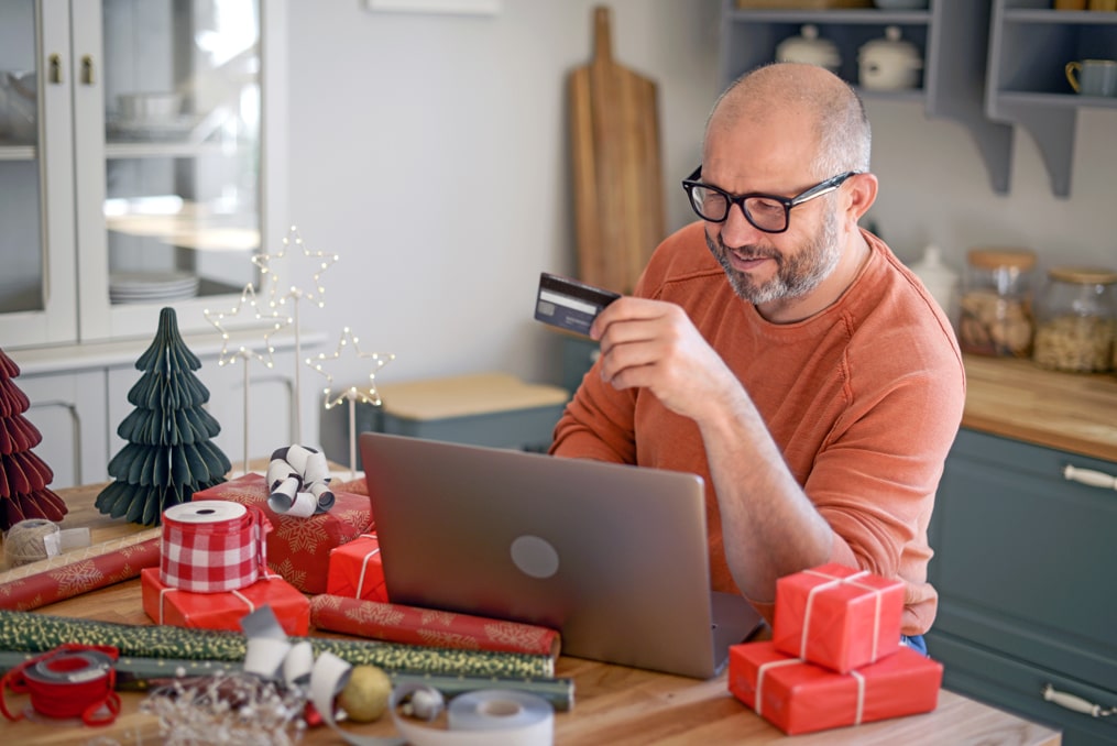 how to avoid holiday shopping scams-man ordering gifts online during the holidays